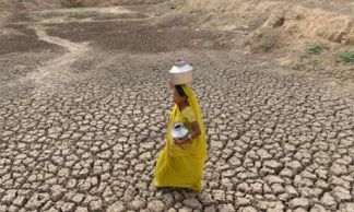 An Indian woman carriea an empty water pot as she crosses the dry bed of a pond at Mehmadpur village, some 20 kms from Ahmedabad on July 8, 2014. Western India's Gujarat state is bracing for a possible drought owing to very scant monsoon rains till date as the new government is due to present its first full budget on July 10, 2014, which economists expect to contain a credible outline of steps to steer India from a subsidy-laden, bureaucratic culture to a more business-friendly investment climate. AFP PHOTO / Sam PANTHAKYSAM PANTHAKY/AFP/Getty Images